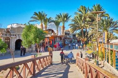 DAHAB, EGYPT - DECEMBER 25, 2017: The tourist street of resort stretches along the shore of Aqaba gulf and boasts numerous stores and restaurants, on December 25 in Dahab. clipart