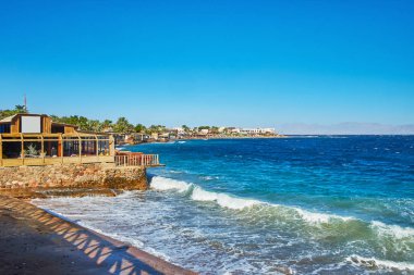 Fırtına dalgaları sahil Dahab Resort, görünüm üzerinde rocky Dağları, Suudi Arabistan, Akabe Körfezi'nde yer alan taşırken, Sinai, Mısır.