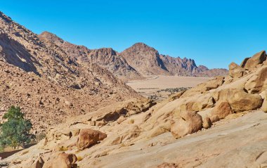 St Catherine şehrin kayalık manzara keyfini çıkarın, nazik yamaç tarafından dağ Sinai, Mısır çevrili çöl vadi üzerinde görünümünü açar.