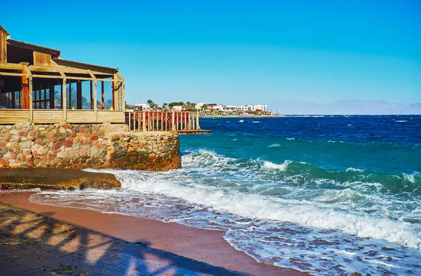 Kıyı Restoranlar, oteller ve puslu dağlar deniz, Sinai, Mısır gördün Saudy Arabistanlı bir görünüm ile Dahab kumlu plaj tatil boyunca yürümek.