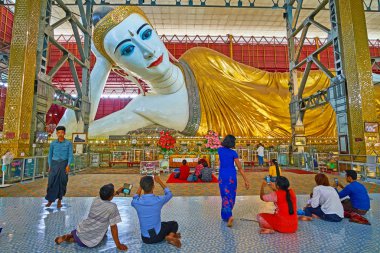 Yangon, Myanmar - 27 Şubat 2018: Kulları üzerinde 27 Şubat Yangon olarak Chaukhtatgyi Buda resim, önünde oturan resimler yapmak.