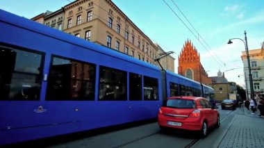 Krakow, Polonya - 12 Haziran 2018: Meşgul tüm azizler kare hızlı trafik, birçok yayalar ve Grodzka street, 12 Haziran Krakow townhouses arkasında üzerinde kutsal Trinity Bazilikası ile.