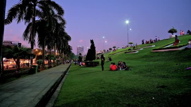 ヤンゴン ミャンマー 2018 インヤ湖公園は芝生でリラックス 通行人と乗用の車 友人や家族とピクニックを楽しむ ヤンゴンで 夕日を満たすために最適な場所 — ストック動画