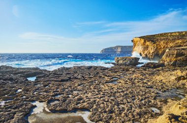 San Lawrenz kıyısındaki dağ manzarası fırtınalı dalgalara bakıyor, kayalara ve kayalıklara çarpıyor, Gozo Adası, Malta.