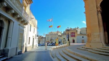 Guastalla, Malta - 16 Haziran 2018: San Nikola sokak eski 16 Haziran'da Guastalla içinde St Nicholas Parish Kilisesi, önünde Meydanı'nda şehir manzaralı tarihi Konakları ile bayraklar.