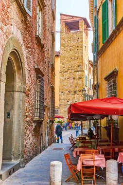 Lucca, İtalya - 30 Nisan 2013: Güzel açık kafe dar Ortaçağ sokakta kırmızı şemsiye ile en iyi yer bir yemeği ya da üstünde Nisan 30 Lucca şehrindeki bir fincan kahve içmek için var