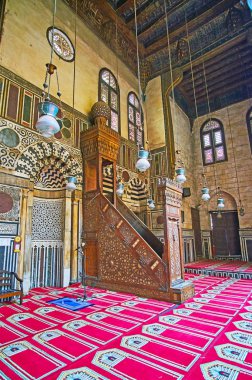 Cairo, Mısır - 21 Aralık 2017: Oymalı ahşap minber (kürsü) Al-Guri cami-medrese Fildişi kakma ile süslü ve duvar, taş mozaik tarafından 21 Aralık Kahire'de çevrili