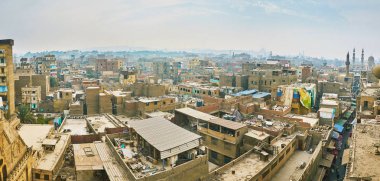 Panorama üzerinden Al-Guri cami-medrese Minare: ormanın eski gecekondu, toz ve eski buldings, Kahire, Mısır arasında yükselen Ortaçağ minareleri ile kaplı.