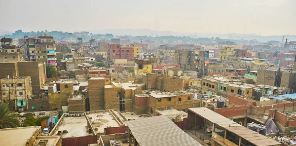 The poor urban slum neighborhoods occupy the large area in historic Islamic Cairo district, shabby buildings of earthen brick are partly unfinished or destroyed and littered with garbage, Egypt.