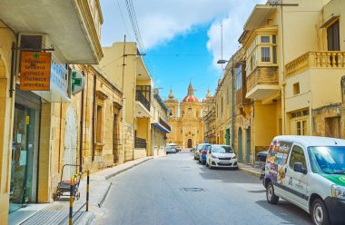 Xaghra, Malta - 15 Haziran 2018: Yürüyüş büyük doğuş Bazilikası'nın 15 Haziran Xaghra mesafe manzaralı dar sokak.