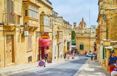 Victoria, Malta - 15 Haziran 2018: Taş yapılardır, turist mağazaları, Belediye duvarına yan ve arka planda 15 Haziran Victoria St George bazilikanın kubbe büyük Ortaçağ cityscape.