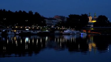 Tekne ve St Michael Archangel kilisenin arka plan, Krakow, Polonya ışıklı yüzen ile Vistula Nehri'nin Karanlık sular.