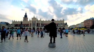 Krakow, Polonya - 12 Haziran 2018: siyah vintage ceket ve silindir şapka Main Market Square Cloth Hall ile arka planda, MIME sanatçı performansı üzerinde 12 Haziran Krakow keyfini çıkarın.
