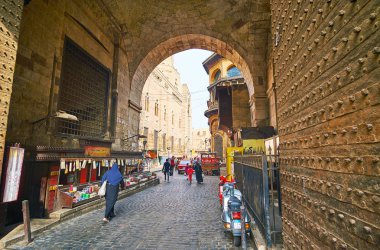 Cairo, Mısır - 21 Aralık 2017: Belgili tanımlık otomobil ve yayalar kullanım dar tarihi geçmek o günü 21 Aralık Kahire, Mısır içinde küçük bir pazar mağazasıyla Bab Zuwayla kapıdan.