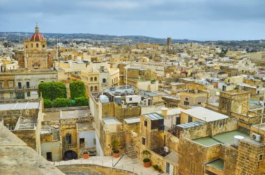 Victoria St George Parish Kilisesi ön, Gozo, Malta üzerinde sol ve yerel kalker konut mahalleler ile tarihi konut.