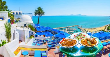 Tavuk ve plajda bir görünüm ve Tersane arka plan, Sidi Bou Said, Tunus ile geleneksel restoran verandada haşlanmış sebzeler ile lezzetli kuskus.