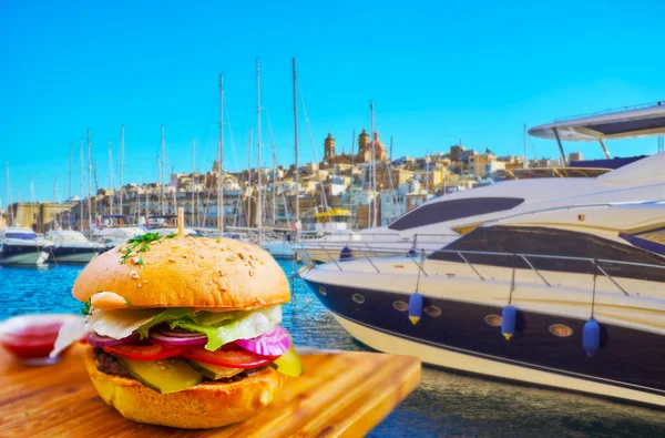 Vittoriosa marina is nice place to enjoy fresh tasty burgers in one of local cafes and watch the yachts, moored at the shipyards, Birgu, Malta.