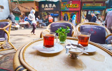 Cairo, Mısır - 21 Aralık 2017: bir bardak sıcak çay üzerinde 21 Aralık Kahire'de mağaza ve yerel pazar tezgahları ile işgal meşgul Al Khayama sokakta bulunan açık çayevinde taze nane ile hizmet veren, zevk.