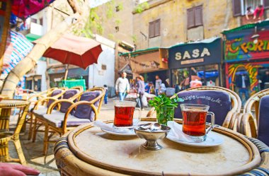 Cairo, Mısır - 21 Aralık 2017: İki bardak sıcak siyah çay Al Khayama sokak açık Cafe mağazaları, satıcılar, eski püskü evleri ve yoldan geçenler tarafından 21 Aralık Kahire'deki bir görünüm ile taze nane ile.