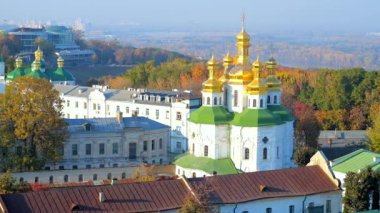The foggy skyline with a view on All Saints church of Kyiv Pechersk Lavra monastery, lush forests, covering the city hills, Dnieper river and Northern (Pivnichnyi) bridge, Ukraine.