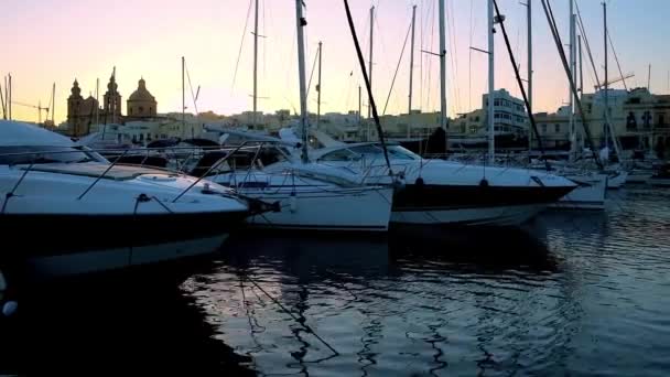ヨット ボート 設定日 マルタを隠す教区教会をほぶ切りのビューとムシダの港の夜を楽しむ — ストック動画