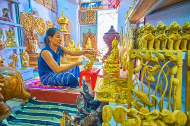 Mandalay, Myanmar - 23 Şubat 2018: Genç kadın Lord Buddha heykelciği altın ile süsle, 23 Şubat Mandalay yapraklar