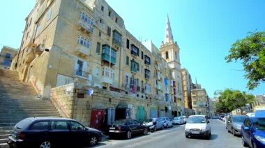 Valletta, Malta - 19 Haziran 2018: Doğum tarihi konut ve çan kulesi St Paul Anglikan Pro-Cathedral, Haziran 19 Valletta manzaralı Marsamxett cadde boyunca trafik
