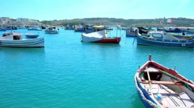 Marsaxlokk, Malta - 18 Haziran 2018: Tekne liman manzaralı köyün sahil mesire ve tepeler üzerinde 18 Haziran Marsaxlokk içinde arka plan üzerinde Delimara yarımadasının boyunca yürüyüş