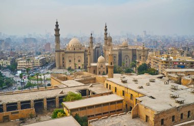 İslami Kahire, Al Rifai sadece büyük binaların konut dörtte beyaz akşam sis kapsar ' ve uzun boylu minare ile Sultan Hassan cami görülür açıkça, Mısır.