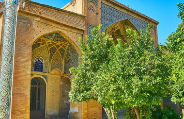 Zengin bir şekilde dekore edilmiş portal (Iwan) Hafezieh doğal kiremitli süsler, oyulmuş tuğla süslemeleri ve yemyeşil bahçe önündeki, Şiraz, Iran.