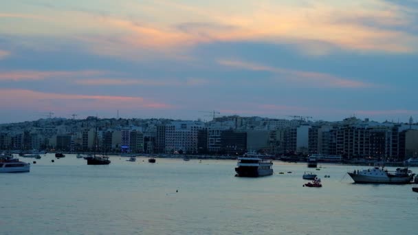 スリーマの背景と風光明媚な Cloudscape マルタ 水表面に反映して近代的な住宅地港の夕暮れ — ストック動画