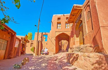 Abyaneh, Iran - 23 Ekim 2018: İki Abyanaki kadınların geleneksel kıyafetleri köyde üzerinde 23 Ekim Abyaneh yılında turist mağaza yanındaki sokak konuşmak