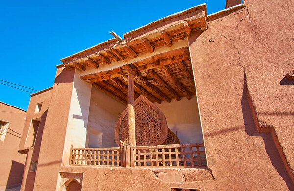 The iwan (portal) of small village mosque with wooden ceiling and column, Abyaneh, Iran.