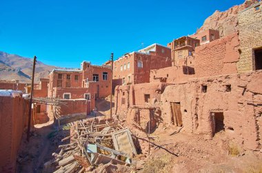 Abyaneh dağ köyü ile Ortaçağ korunmuş eski sokakta çöp dökümü evler ve binalar ve etrafında Iran terk.