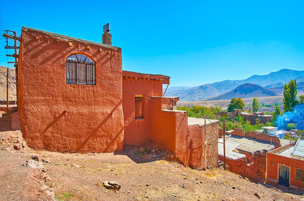 The terrace adobe  houses on the mountain slope of Abyaneh village with the Karkas mountains on background, Iran.