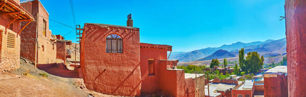 Panorama of Abyaneh village from its hilly street with a view on old clay buildings and Karkas mountains on background, Iran.