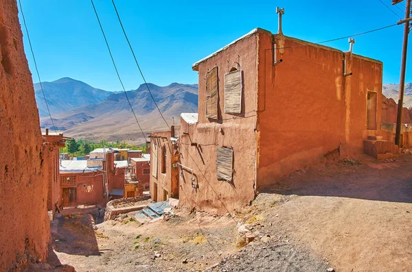 The steep descent with bad mud road due to the often landfalls in historic Abyaneh village, famous for its medieval preserved red mud houses, Iran.