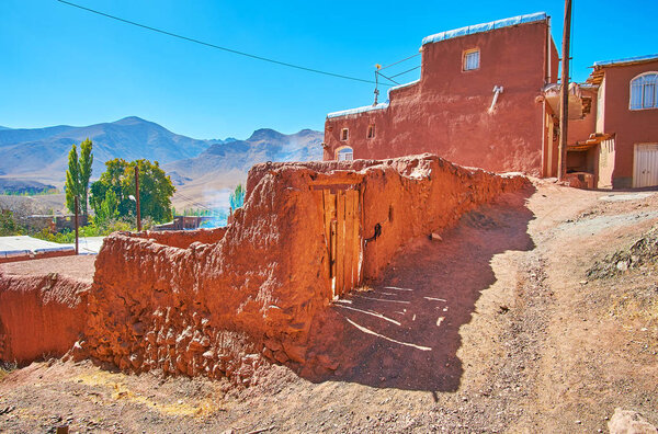 The hilly streets of Abyaneh open the view on the Karkas mountains, surrounding the red village, Iran.