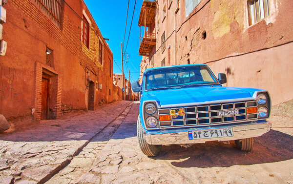 ABYANEH, IRAN - OCTOBER 23, 2017: The vintage blue car is parked in medieval street of historic mountain village, on October 23 in Abyaneh