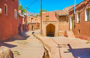 Abyaneh eski sokakta yürüyorum ve korunmuş ortaçağ eskisi - uzun tünel, Iran ile iyi yeraltında su kemerli dış keşfetmek.