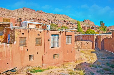 Kayalık tepe ve kırmızımsı adobe evler tarihi Abyaneh Köyü, Iran ile Karkas dağ yamacında.
