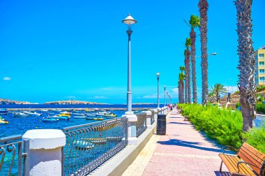 Bugibba, Malta - 14 Haziran 2018: Seaside rahat mesire St. Paul's Bay Marina üzerinde 14 Haziran Bugibba içinde harika sayısı tadını çıkarmak için çok sayıda banklar ile.