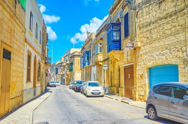 Mosta, Malta - 14 Haziran 2018: Dar sokak içinde eski kasaba Mosta tarihi Konakları ile bazı geleneksel ahşap Malta balkonlar üzerinde Haziran 14 Mosta dekore