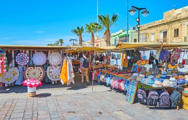 Marsaxlokk, Malta - 18 Haziran 2018: Turizm Pazar sahil mesire parçası kaplayan ve Başak hatıra(lık) anmalık, geleneksel Malta parçaları ve aksesuarları, Haziran 18 Marsaxlokk içinde sunar.