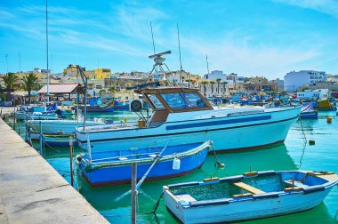 Büyük balıkçı limanı popüler turistik köyün ahşap tekneler yumuşak dalgalar, Marsaxlokk, Malta dans..