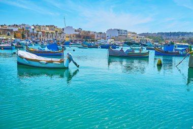Marsaxlokk, Malta - 18 Haziran 2018: luzzu tekneler, eski balıkçı köyü, huzurlu bir atmosfer ve güzel görünümleri, Haziran 18 Marsaxlokk limanında demirlemiş sallanan üzerinde manzarasının tadını çıkarın.