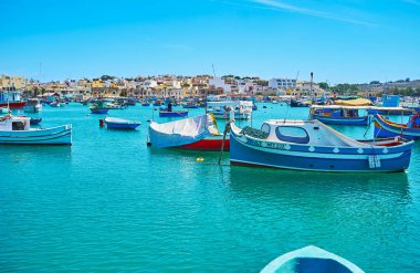 Marsaxlokk, Malta - 18 Haziran 2018: Balıkçı tekneleri Marsaxlokk Marina çizgili eski taş evler arka plan üzerinde 18 Haziran Marsaxlokk içinde