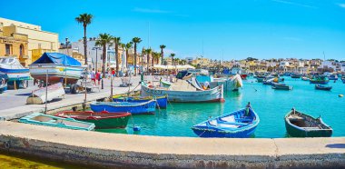 Marsaxlokk, Malta - 18 Haziran 2018: Panoramik Marina luzzu tekneler ve sahil tatil köyü, turistik kafe, Hediyelik eşya mağazaları ve mimari tarihi yerler, sahil mesire ile 18 Haziran Marsaxlokk içinde