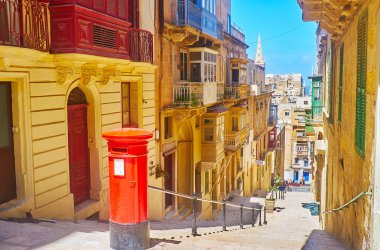 Vintage kırmızı İngiliz posta kutusunun ortasında merdiven Vassali sokak, Valletta, Malta.
