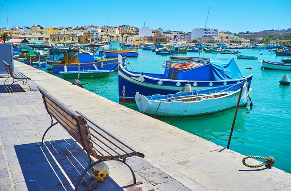 港に沿ってベンチがいい場所をボートを見るし 釣り村のマルサシュ ロック マルタの雰囲気をお楽しみください — ストック写真